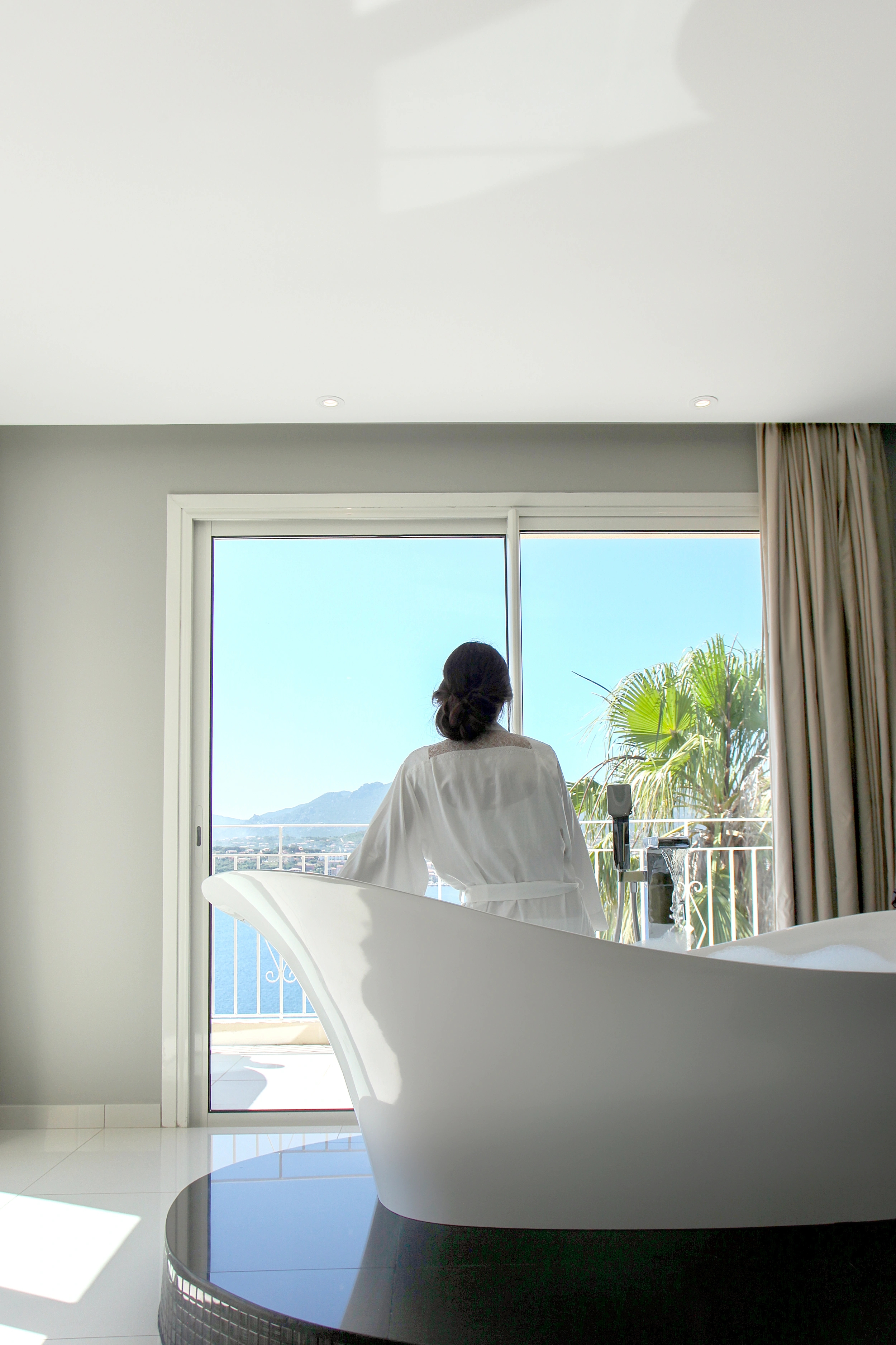 Grand salon lumineux avec mobilier moderne et baies vitrées vue sur la mer