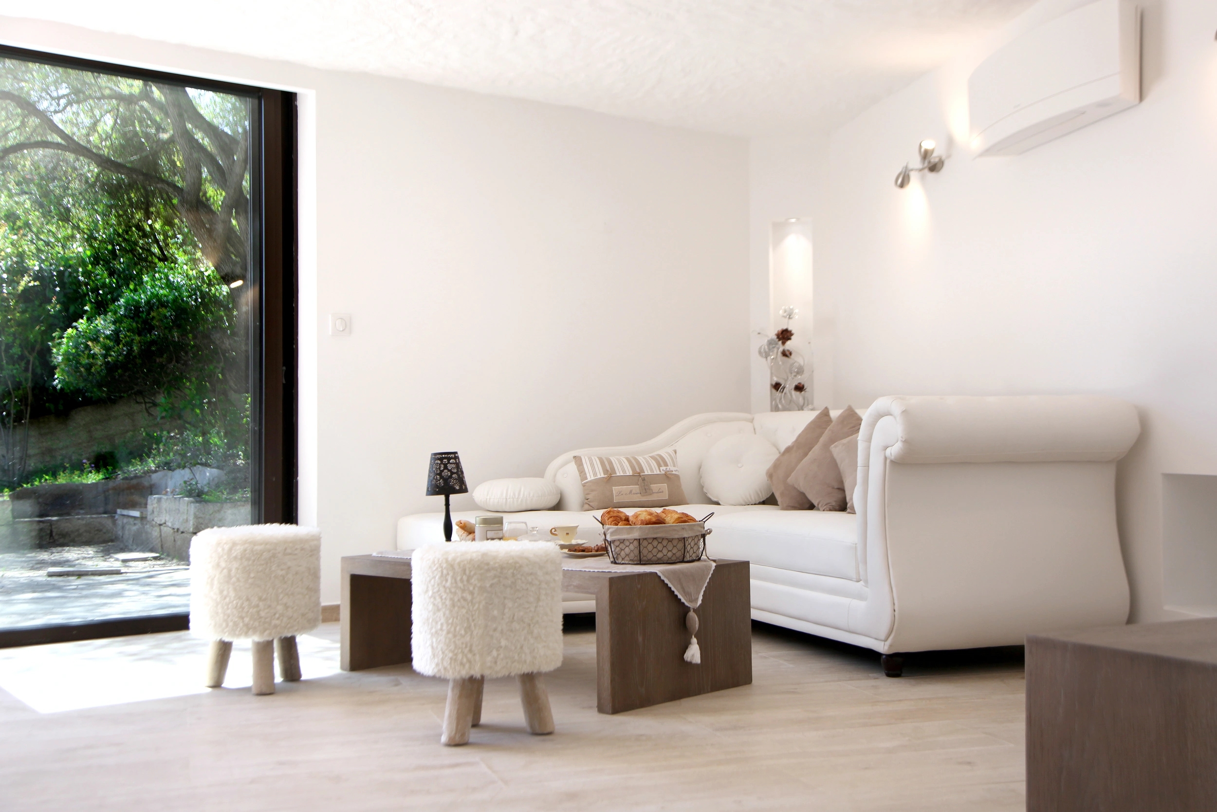 Salon spacieux et lumineux avec mobilier contemporain et baies vitrées panoramiques dans la villa privée de l'hotel Marinca