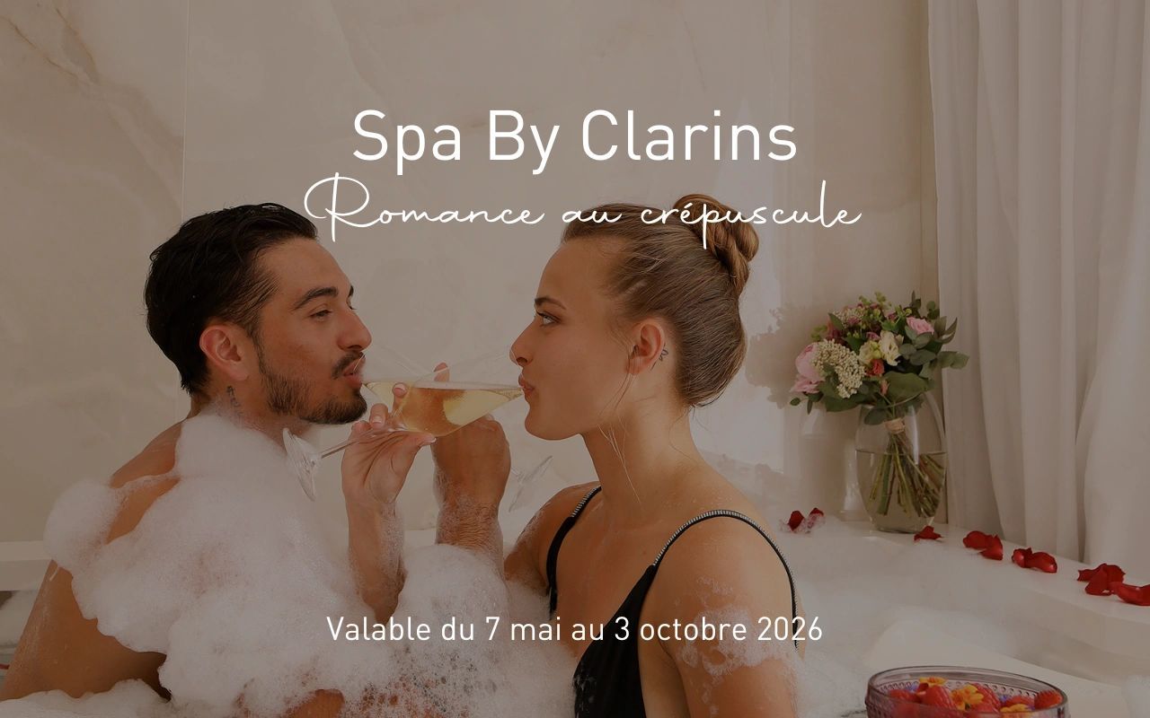 Couple romantique dans un bain moussant avec pétales de roses chez Spa By Clarins