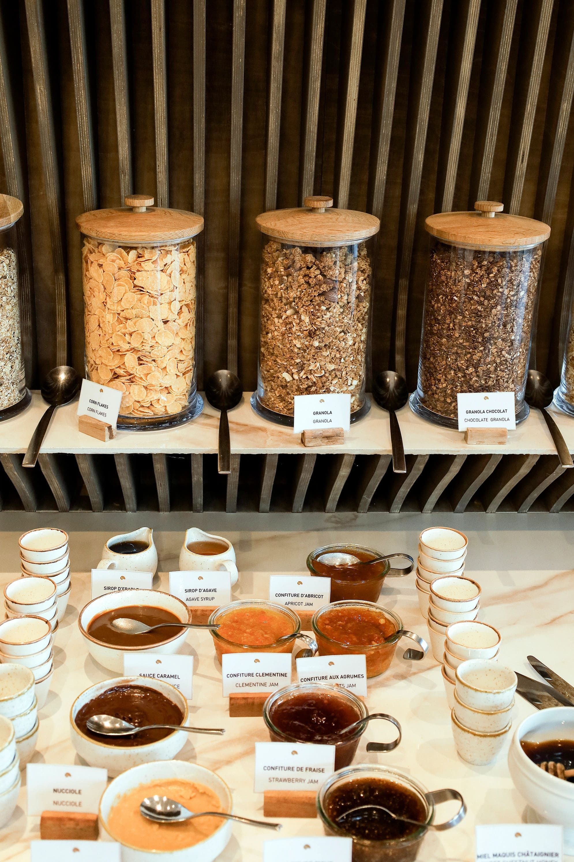 Présentoir de petit-déjeuner avec céréales, granola et confitures artisanales en pots et bocaux