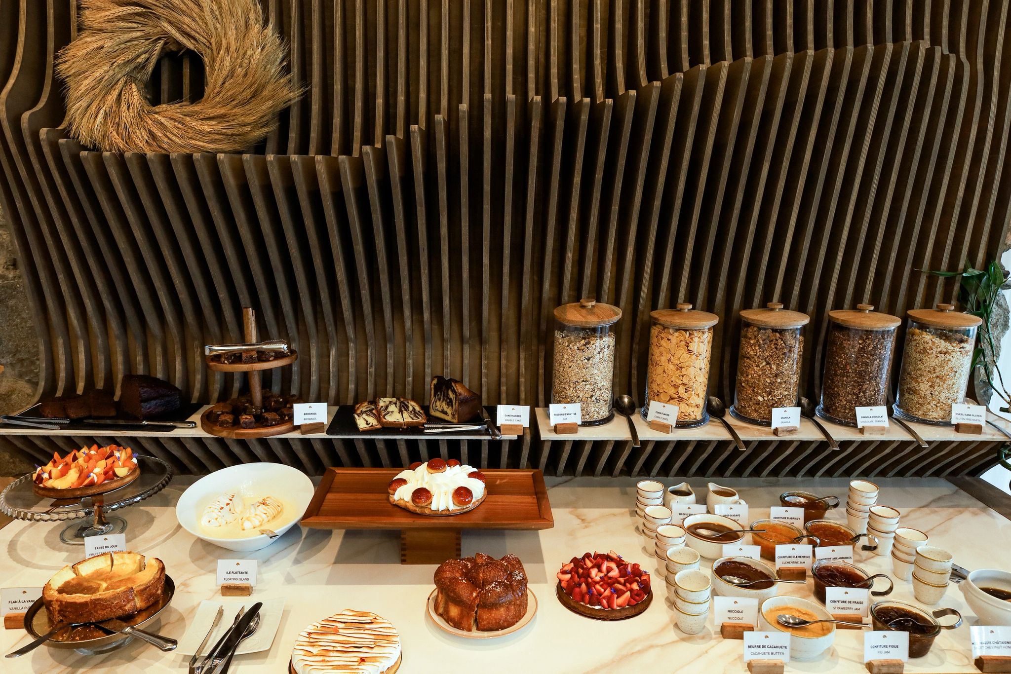 Buffet de pâtisseries et desserts avec gâteaux, fruits rouges, pots de céréales et condiments sur fond de bois