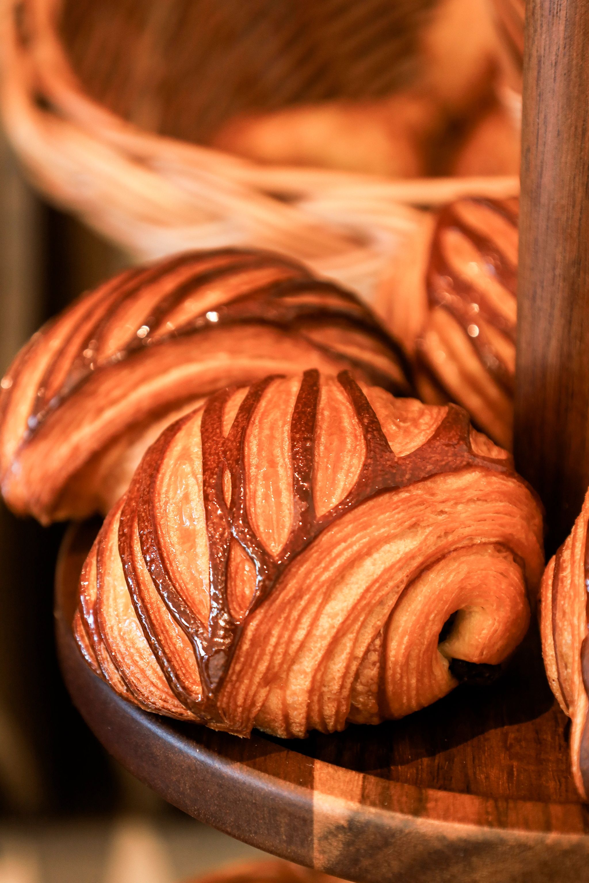 Croissants feuilletés dorés disposés dans un panier en bois, pâtisserie française artisanale