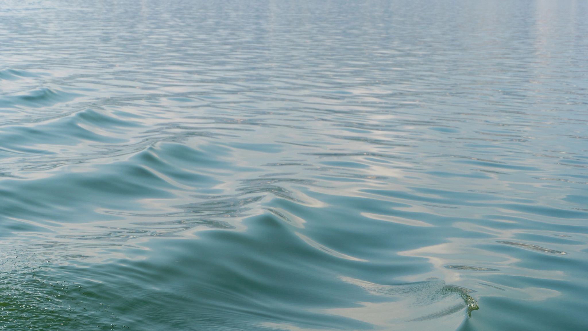 Vagues calmes et régulières de l'océan avec reflets de lumière sur l'eau bleue turquoise