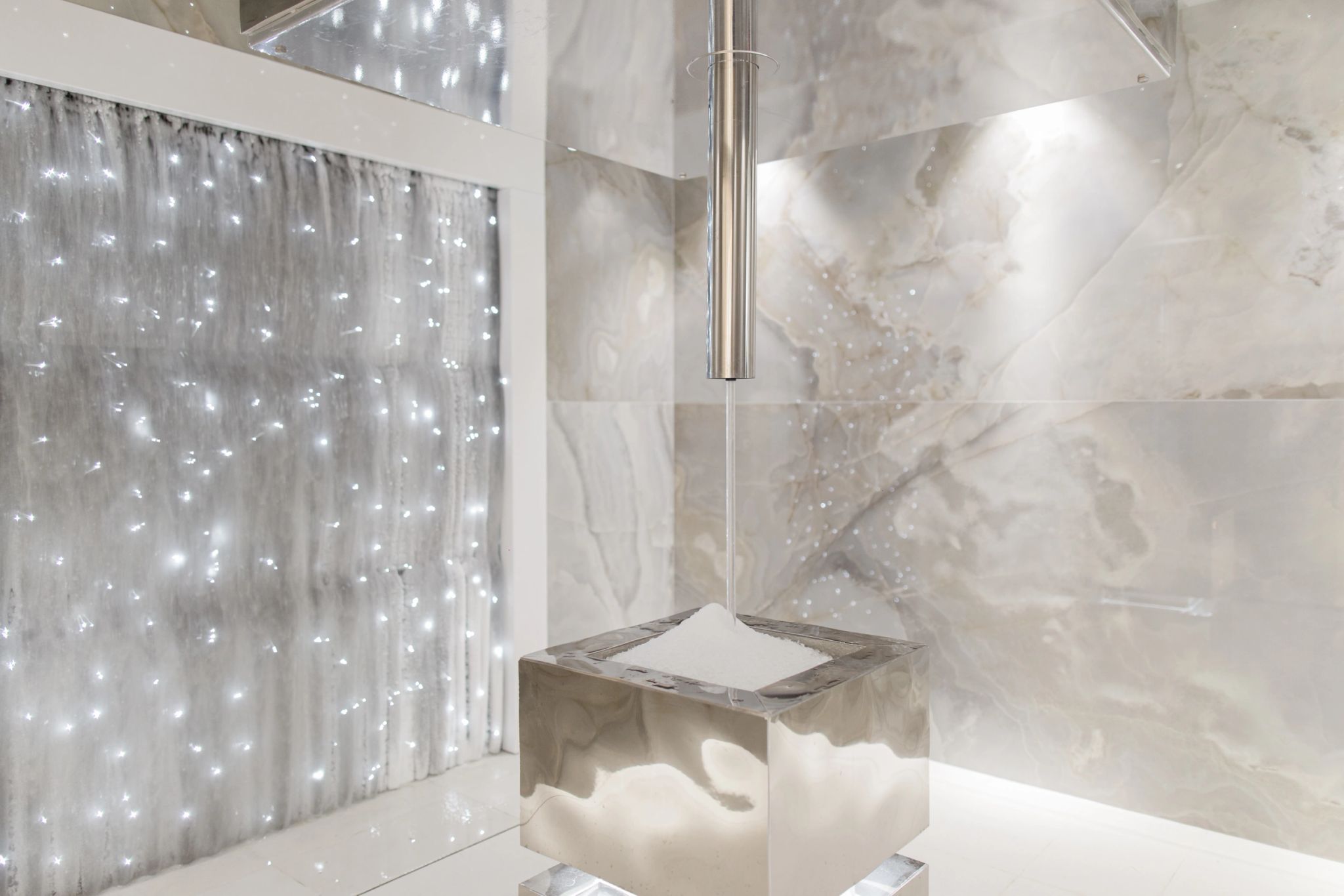 Douche moderne avec parois en marbre beige et rideau gris avec guirlandes lumineuses LED blanches